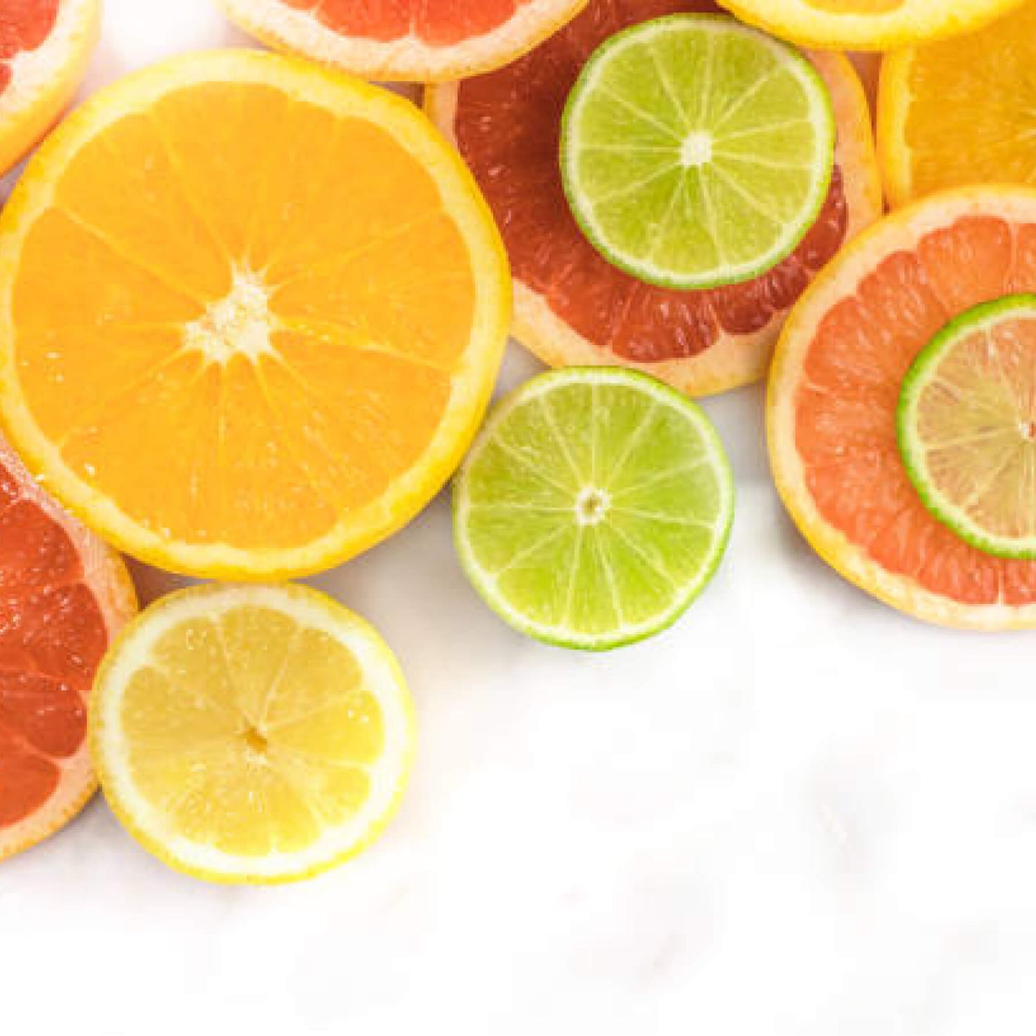 Sliced citrus fruits including oranges, lemons, grapefruits, and limes on a white background.